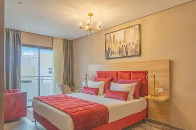 a bedroom with a large bed with red pillows at Rent-inn Boutique Hotel in Rabat