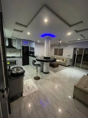 a large kitchen with a table in the middle of a room at Appartement meublé à louer Rabat in Rabat