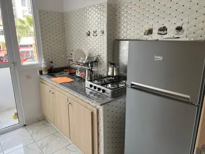 a kitchen with a refrigerator and a stove at Appartement chic in Tit Mellil