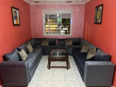 a living room with a couch and a table at Appartement chic in Tit Mellil