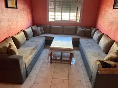a living room with a large couch and a table at Appartement chic in Tit Mellil