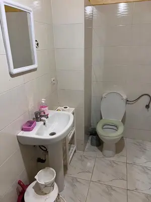 a bathroom with a sink and a toilet and a mirror at Appartement chic in Tit Mellil