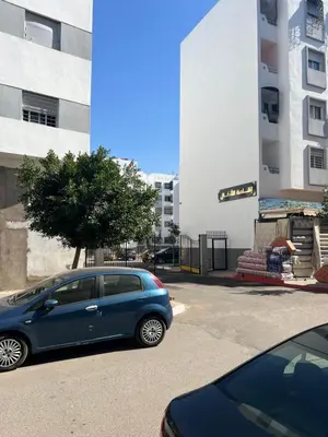 a blue car parked in front of a building at Appartement chic in Tit Mellil