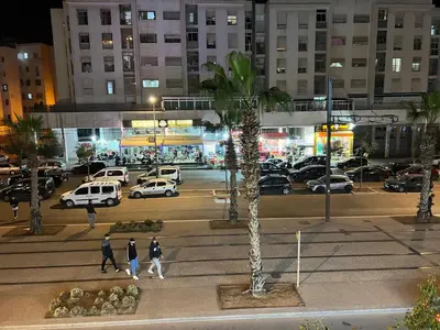 a group of people walking in a city at night at Appartement chic in Tit Mellil