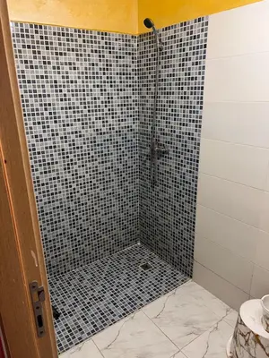 a bathroom with a shower with black and white tiles at Appartement chic in Tit Mellil