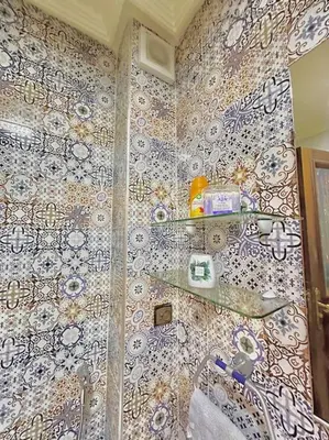 a bathroom with a shower with a tile wall at Lilias Appart - 2 Mars in Casablanca