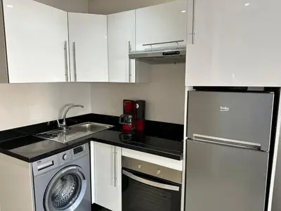 a kitchen with white cabinets and a washing machine at Racine Studio bd Anfa in Casablanca