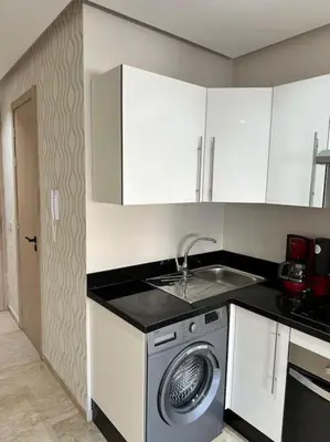 a kitchen with a sink and a washing machine at Racine Studio bd Anfa in Casablanca
