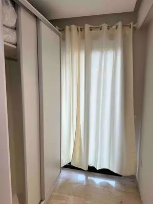 a white curtain in a room with a closet at Racine Studio bd Anfa in Casablanca