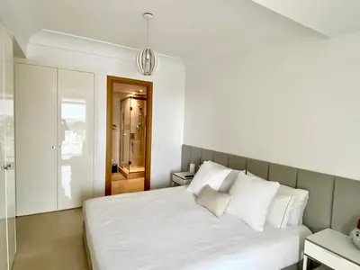 a bedroom with a large white bed with white pillows at Anfa Finance City CFC! Magnifique Apt Tours Végétales, grande terrasse, piscine, parking in Casablanca