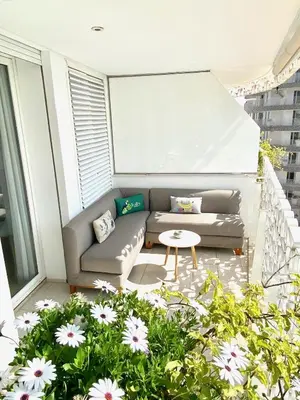 a balcony with a couch and some flowers at Anfa Finance City CFC! Magnifique Apt Tours Végétales, grande terrasse, piscine, parking in Casablanca