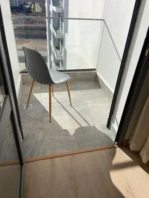 a chair sitting on a balcony next to a window at Luxueux Appart à 5 min aéroport mohamed 5 in Nouaceur
