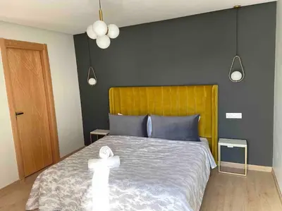 a bedroom with a large bed with a yellow headboard at Luxueux Appart à 5 min aéroport mohamed 5 in Nouaceur