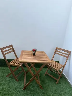 a wooden table and two chairs with flowers on it at Studio anfa plaza in Casablanca