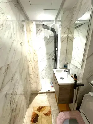 a white bathroom with a shower and a sink at Studio anfa plaza in Casablanca