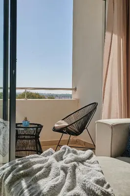 a bedroom with a bed and a chair and a window at YourPlace Rabat - Royal Residence in Rabat