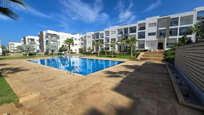 a building with a swimming pool in front of a building at Le doux refuge - à 7 mn de la plage à pieds in Temara