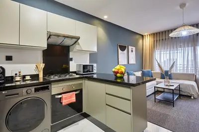 a kitchen with a dishwasher and a living room at Charming 1 Bed Casablanca Retreat With Free Parking in Casablanca