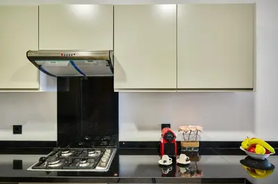 a kitchen with a stove and white cabinets at Sleek and Modern 2-Bed Unit in Downtown Casa in Casablanca