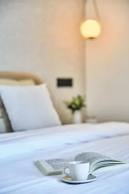 a book and a cup of coffee on a bed at Sleek and Modern 2-Bed Unit in Downtown Casa in Casablanca