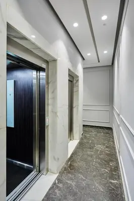 an elevator lobby with a black door and marble floors at Sleek and Modern 2-Bed Unit in Downtown Casa in Casablanca