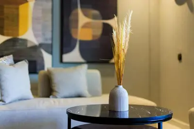 a vase on a table in a living room with a couch at Chic & Spacious : 3BR Apartment in Central Rabat in Rabat