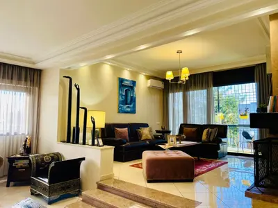 a living room with a couch and a table at Rabat Agdal Pearl - 2BR Spacious & Well located in Rabat