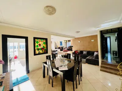 a dining room and living room with a table and chairs at Rabat Agdal Pearl - 2BR Spacious & Well located in Rabat