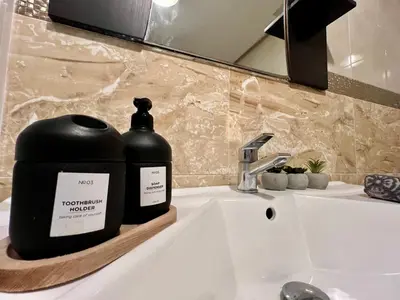 a bottle of soap sitting on a bathroom sink at Rabat Agdal Pearl - 2BR Spacious & Well located in Rabat