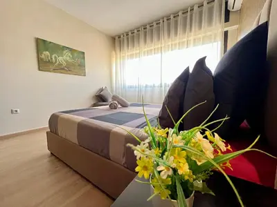 a bedroom with a bed and a couch and a window at Rabat Agdal Pearl - 2BR Spacious & Well located in Rabat