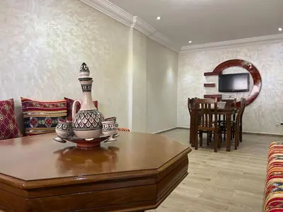 a living room with a table with a vase on it at appart casa voyageurs belvédère in Casablanca