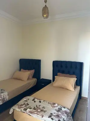 a room with two beds with blue headboards at appart casa voyageurs belvédère in Casablanca