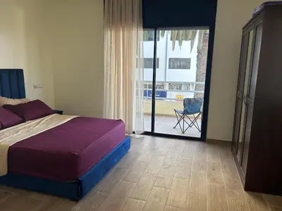 a bedroom with a bed and a door to a patio at appart casa voyageurs belvédère in Casablanca