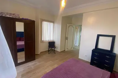 a bedroom with a bed and a dresser and a mirror at appart casa voyageurs belvédère in Casablanca