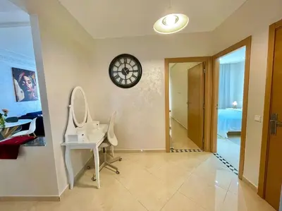 a room with a desk and a clock on the wall at F4 Appartement entièrement neuf au cœur de Témara in Temara