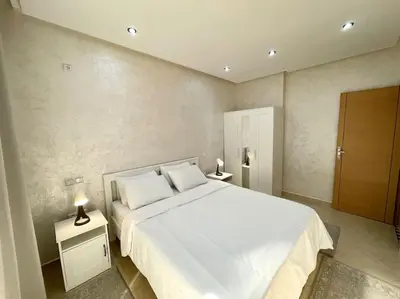 a bedroom with a large white bed and two lamps at F4 Appartement entièrement neuf au cœur de Témara in Temara