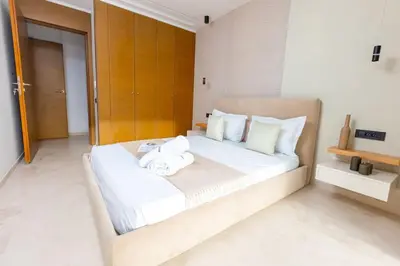 a bedroom with a bed with white sheets and pillows at Aristocratic Abode: Luxurious 2BR Flat in Agdal in Rabat
