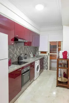 a kitchen with red cabinets and a washer and dryer at Luxurious apartment, European Quality in Casablanca