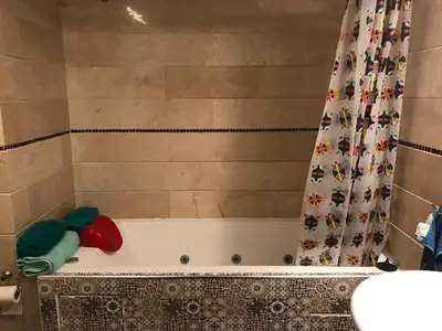 a bathroom with a bath tub with a shower curtain at Luxurious apartment, European Quality in Casablanca