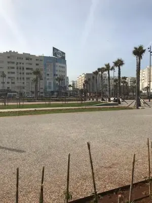 an empty parking lot with palm trees and buildings at Luxurious apartment, European Quality in Casablanca