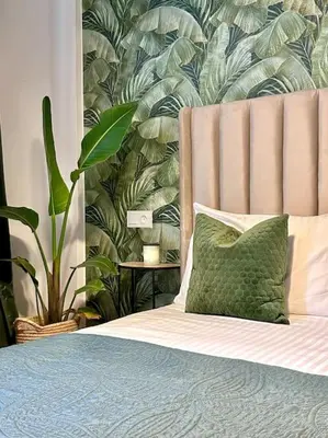a bed with a green pillow next to a plant at Appartametno moderno centro di casa in Casablanca