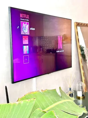 a tv on a wall with a purple screen at Appartametno moderno centro di casa in Casablanca