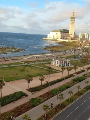 a city with a clock tower next to the ocean at Appartement chic, moderne vue sur mer in Casablanca