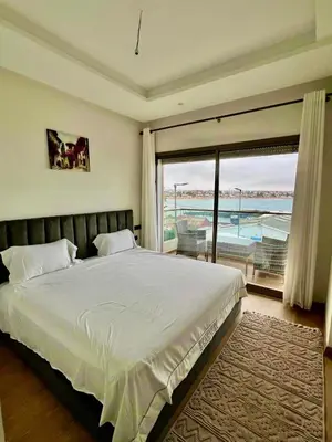 a bedroom with a large bed and a large window at Luxurious Apt - Sea View in Pont Blondin