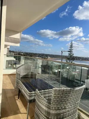 a balcony with a table and chairs and a view of the ocean at Luxurious Apt - Sea View in Pont Blondin