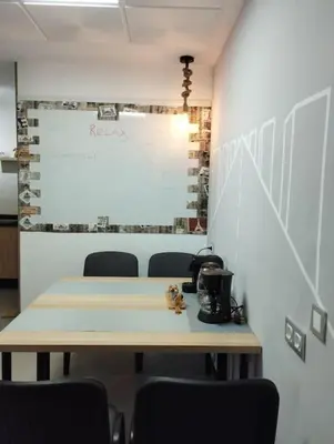 a meeting room with a table and chairs and a white wall at Mohammedia Relax in Mohammedia