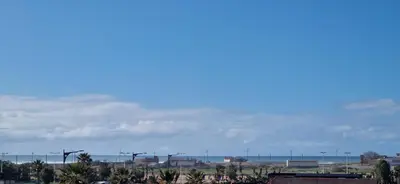 a view of a city with palm trees and the ocean at Zenata ocean park appartement in Mohammedia