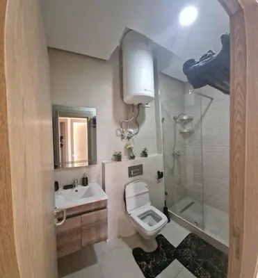 a bathroom with a toilet and a sink and a shower at Zenata ocean park appartement in Mohammedia