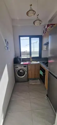 a small kitchen with a stove and a refrigerator at Zenata ocean park appartement in Mohammedia