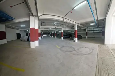 an empty parking garage with white and red columns at Zenata ocean park appartement in Mohammedia